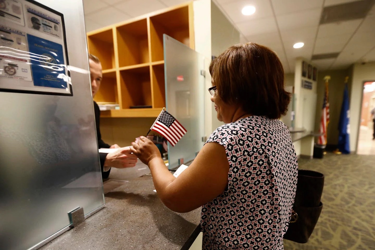 A woman receives a U.S. flag after passing her citizenship interview in Newark, N.J., on May 25, 2016.