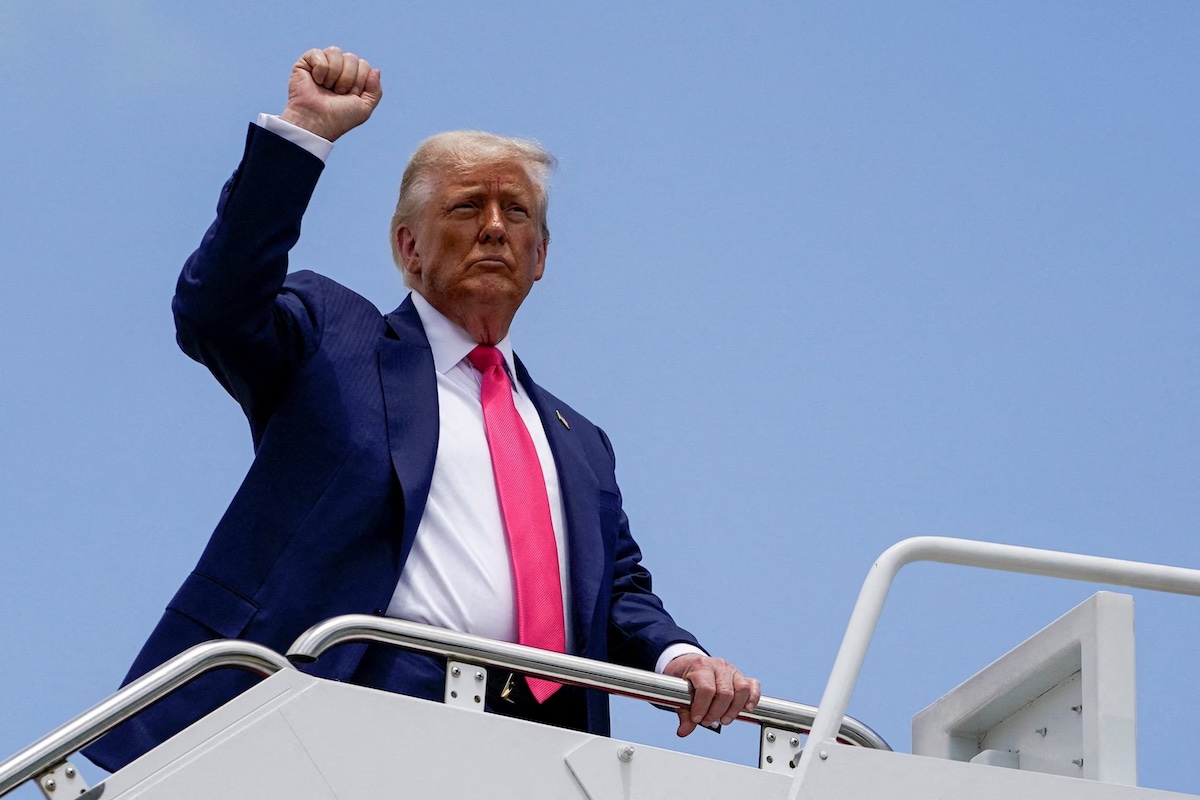 President Donald Trump raises his fist while boarding Air Force One, as he departs for Pennsylvania, at Joint Base Andrews, Md., July 15, 2025.